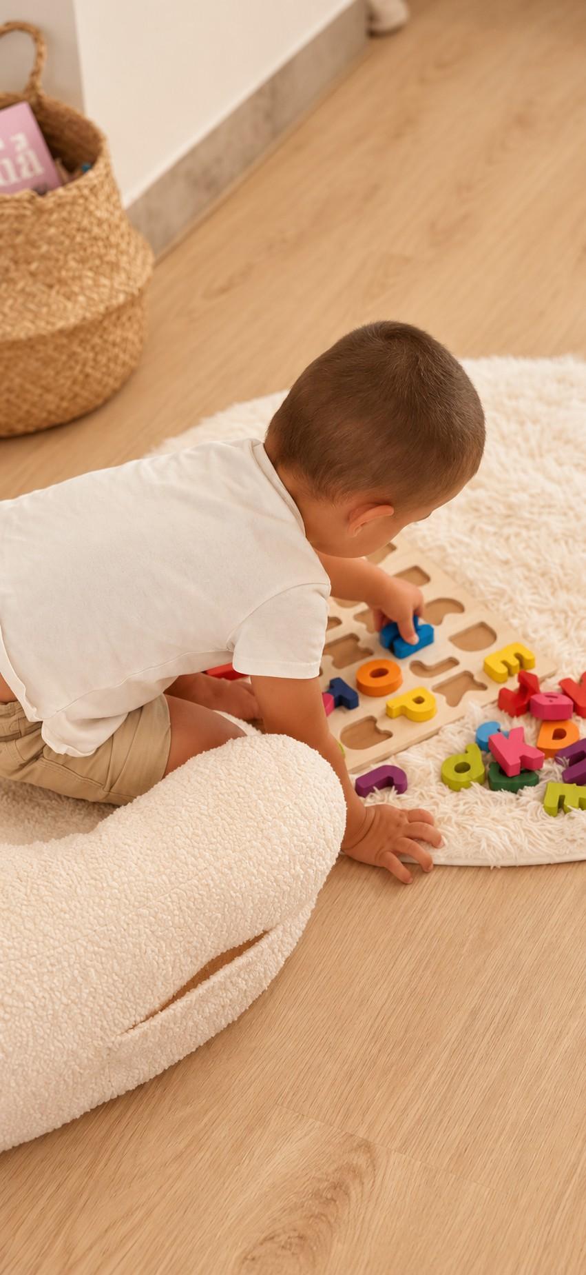 Un niño concentrado en un juego de encajables sobre una alfombra